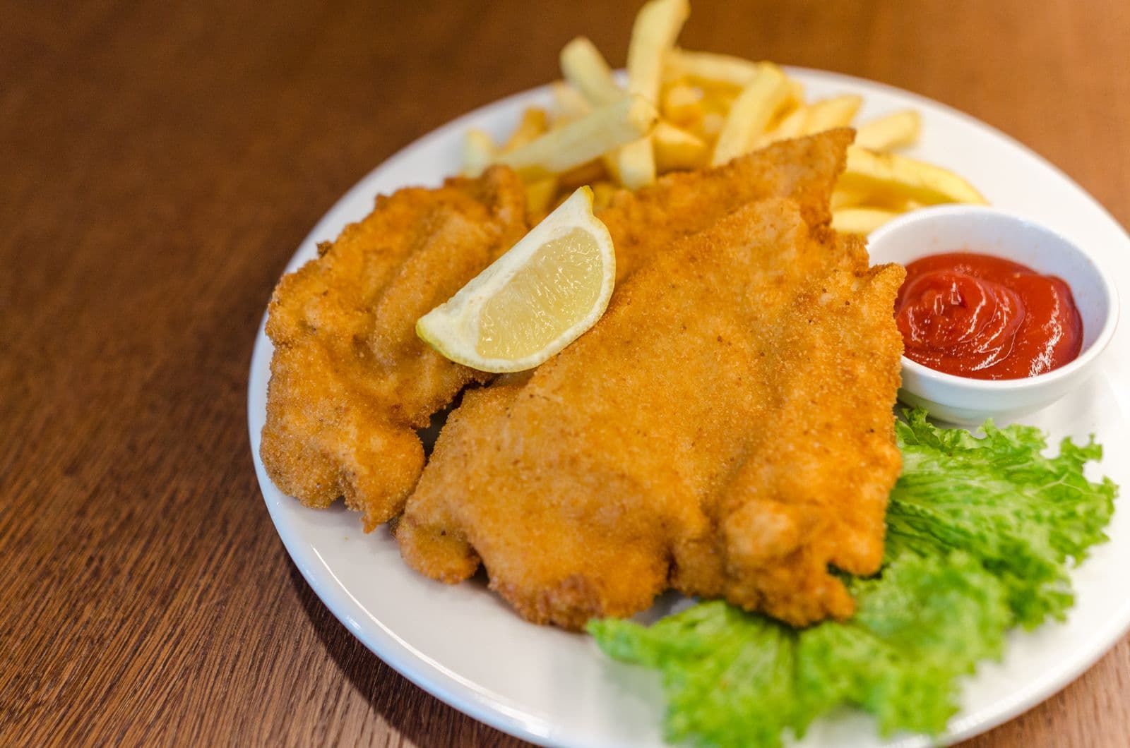 Crumbed chicken schnitzel with oven fries